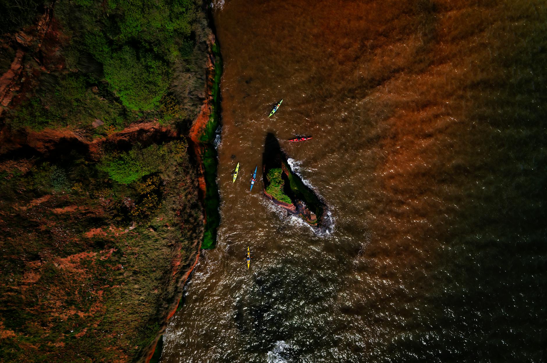 Kajakarze płynący przy klifowym wybrzeżu Sidmouth w Anglii