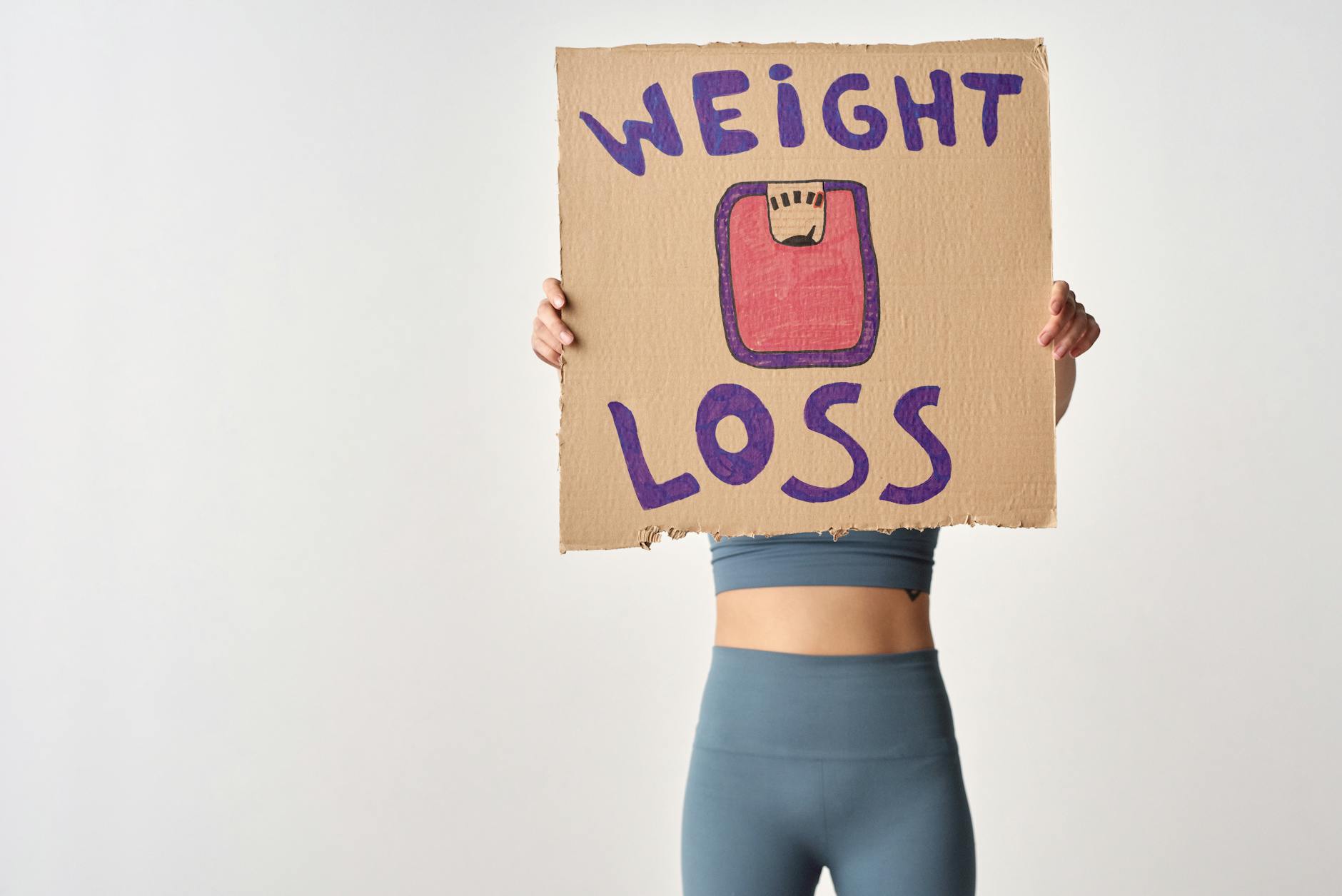Osoba trzymająca kartkę z napisem weight loss jako motywacja do odchudzania