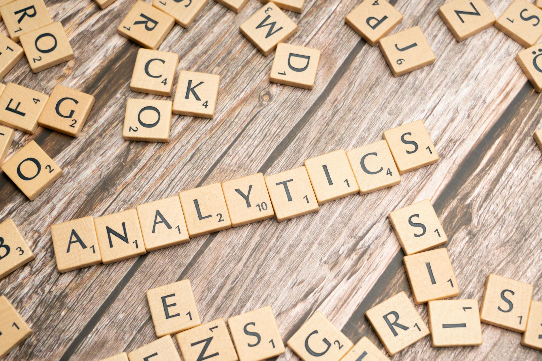 Jak wykrywać obserwacje odstające w R: IQR, Z score i wpływ na wnioski Kafelki Scrabble układające się w napis Analytics na drewnianym tle