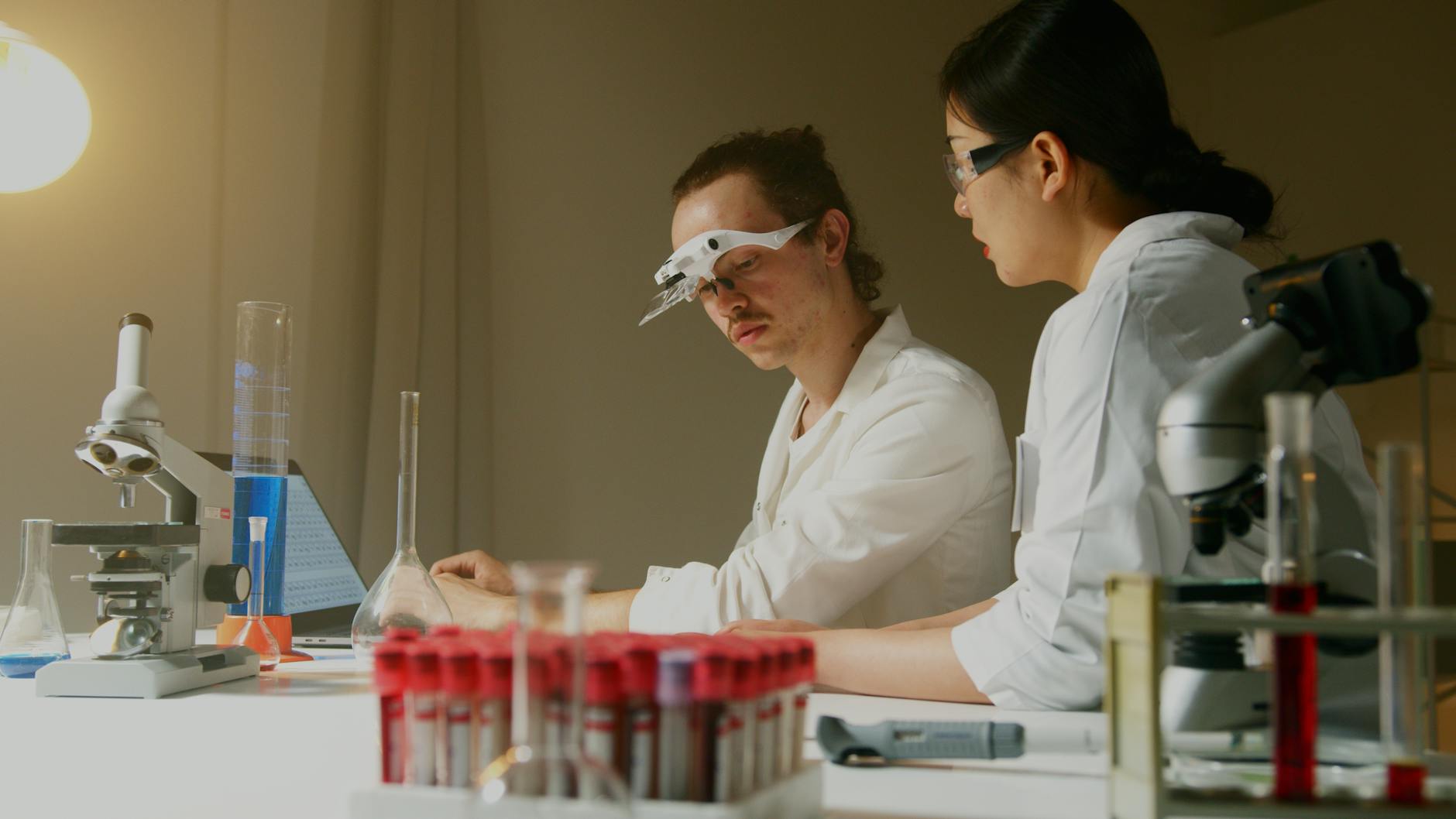 Naukowcy analizują próbki w laboratorium wśród probówek i aparatury